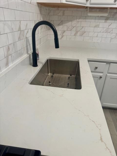 1703 Hermon Ave, Zion, IL 60099 - kitchen view of backsplash, light stone countertops, and white cabinetry