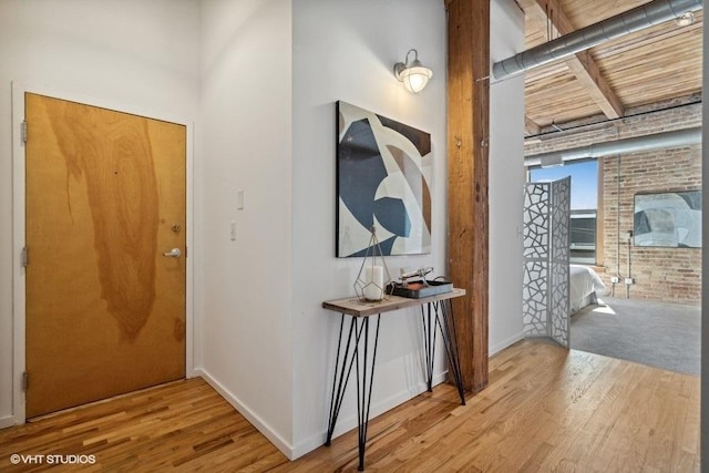 2511 W Moffat St Unit 305-D, Chicago, IL 60647 - foyer entrance with wood finished floors, beamed ceiling, and brick wall