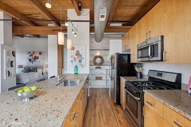 2511 W Moffat St Unit 305-D, Chicago, IL 60647 - kitchen featuring stainless steel appliances, light wood finished floors, light stone countertops, open floor plan, and hanging light fixtures