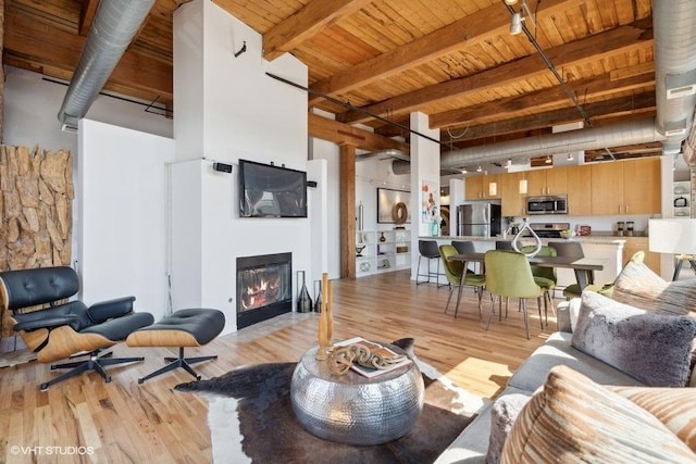 2511 W Moffat St Unit 305-D, Chicago, IL 60647 - living area with light wood-type flooring, a wooden ceiling with exposed beams, and a glass covered fireplace