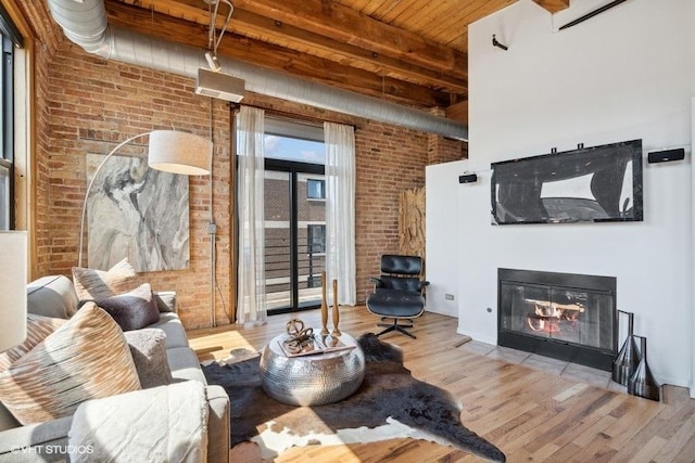 2511 W Moffat St Unit 305-D, Chicago, IL 60647 - living room featuring brick wall, a fireplace with flush hearth, wood finished floors, wooden ceiling, and a high ceiling