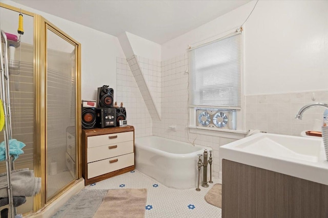 555 Lorraine Ave, Waukegan, IL 60085 - full bath with tile walls, a garden tub, a shower stall, vanity, and tile patterned flooring