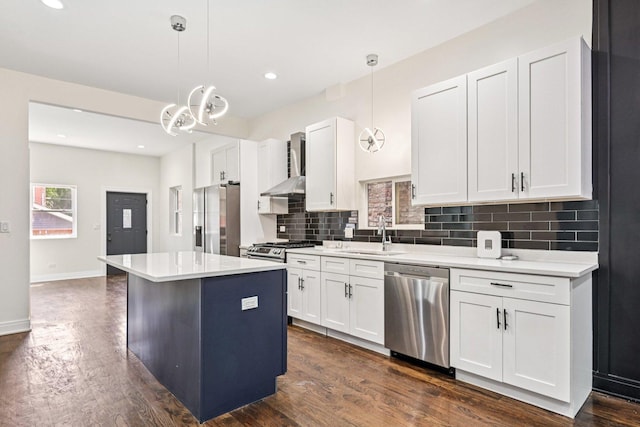 6547 S Langley Ave, Chicago, IL 60637 - kitchen featuring appliances with stainless steel finishes, wall chimney exhaust hood, a center island, tasteful backsplash, and white cabinets