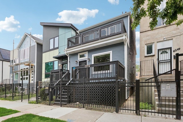 6547 S Langley Ave, Chicago, IL 60637 - multi unit property featuring a balcony, a fenced front yard, a gate, and stairway