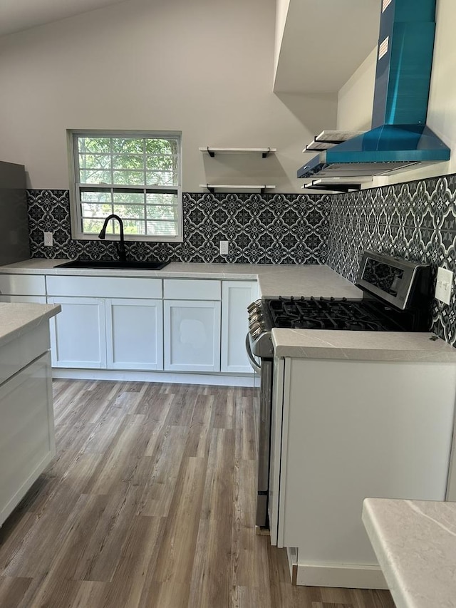 5309 Cleveland Dr, Mchenry, IL 60050 - kitchen featuring ventilation hood, stainless steel range with gas stovetop, white cabinets, and light wood-type flooring