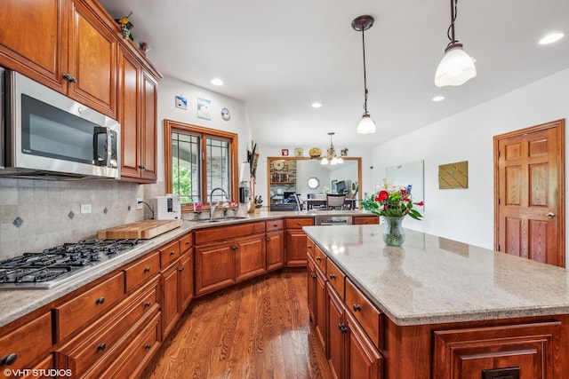 9265 Maura Ct, Frankfort, IL 60423 - kitchen with stainless steel appliances, wood finished floors, a kitchen island, light stone countertops, and recessed lighting