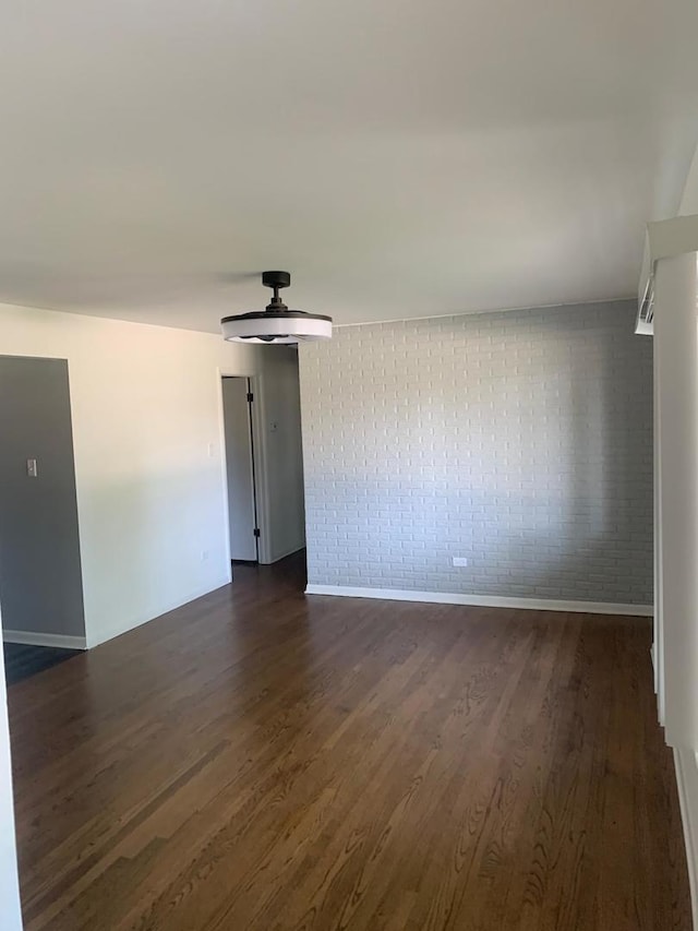 6425 W 83rd Pl, Burbank, IL 60459 - empty room with brick wall, dark wood finished floors, and a ceiling fan