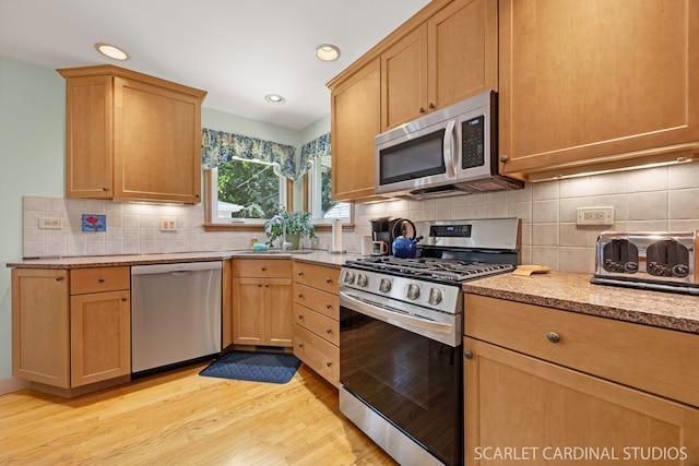412 S Addison Ave, Lombard, IL 60148 - kitchen with appliances with stainless steel finishes, light wood finished floors, decorative backsplash, light stone countertops, and recessed lighting