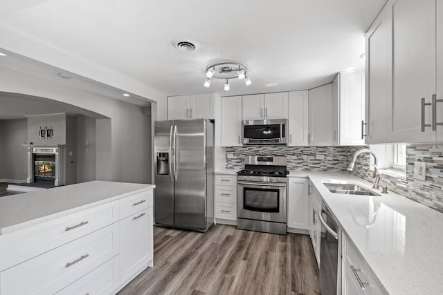 10409 S 83rd Ave, Palos Hills, IL 60465 - kitchen with stainless steel appliances, tasteful backsplash, light stone counters, white cabinetry, and wood finished floors
