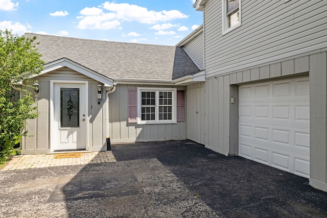 10409 S 83rd Ave, Palos Hills, IL 60465 - view of exterior entry featuring a garage, a shingled roof, and driveway