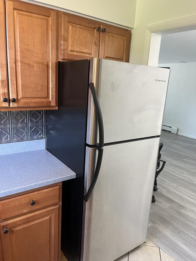 415 Wesley Ave Unit 21, Oak Park, IL 60302 - kitchen with freestanding refrigerator, brown cabinetry, light countertops, and baseboard heating