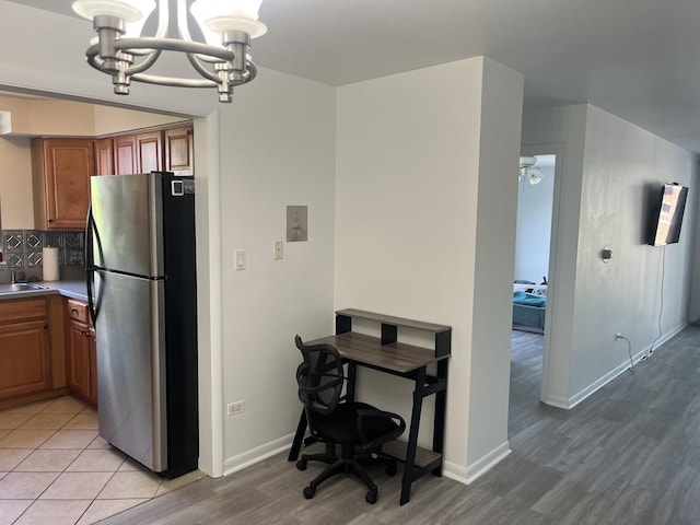 415 Wesley Ave Unit 21, Oak Park, IL 60302 - kitchen with freestanding refrigerator, a chandelier, brown cabinets, light wood-type flooring, and pendant lighting