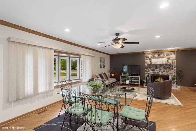 609 N Eastman Dr, Mount Prospect, IL 60056 - dining area with crown molding, ceiling fan, wood finished floors, recessed lighting, and a stone fireplace