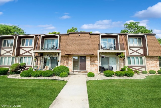 12720 Carriage Ln Unit H2, Crestwood, IL 60418 - view of front facade featuring a balcony, a front yard, brick siding, mansard roof, and roof with shingles