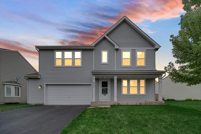 352 Westport Dr, Pingree Grove, IL 60140 - traditional-style house featuring an attached garage, asphalt driveway, a front lawn, and a porch