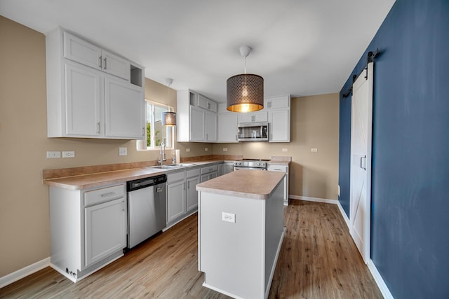 352 Westport Dr, Pingree Grove, IL 60140 - kitchen with appliances with stainless steel finishes, light wood-type flooring, light countertops, a barn door, and white cabinetry