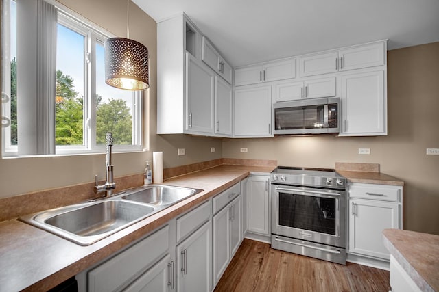 352 Westport Dr, Pingree Grove, IL 60140 - kitchen with stainless steel appliances, white cabinetry, light wood-style floors, light countertops, and pendant lighting