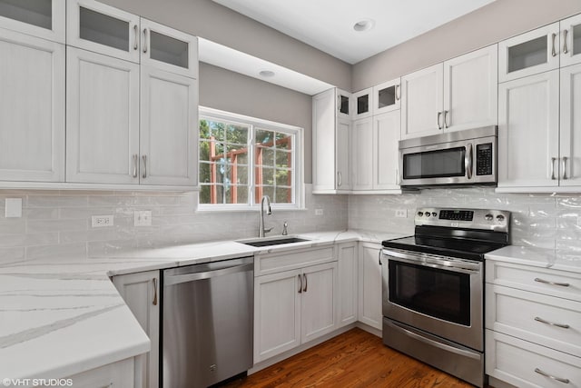 6162 Crossland Blvd, Gurnee, IL 60031 - kitchen featuring appliances with stainless steel finishes, decorative backsplash, light stone countertops, white cabinetry, and dark wood-style floors