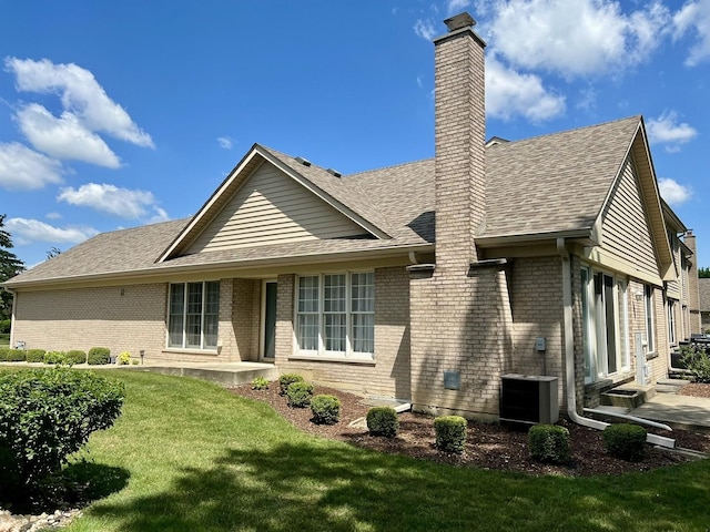 7727 Bristol Park Dr Unit 7727, Tinley Park, IL 60477 - back of property with a chimney, brick siding, a yard, and a shingled roof