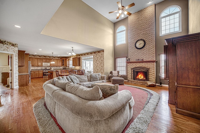 541 Clover Dr, Algonquin, IL 60102 - living room with a ceiling fan, a towering ceiling, light wood-type flooring, a fireplace, and recessed lighting