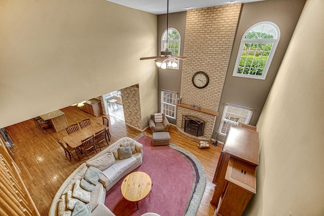 541 Clover Dr, Algonquin, IL 60102 - living room with a high ceiling, healthy amount of natural light, a ceiling fan, wood finished floors, and a brick fireplace