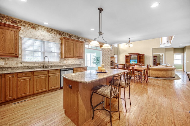 541 Clover Dr, Algonquin, IL 60102 - kitchen with dishwasher, a breakfast bar, light wood-style floors, tasteful backsplash, and light stone counters