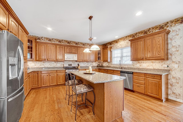 541 Clover Dr, Algonquin, IL 60102 - kitchen with appliances with stainless steel finishes, light wood-type flooring, a kitchen breakfast bar, glass insert cabinets, and wallpapered walls