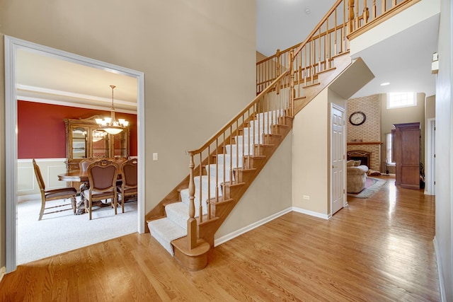 541 Clover Dr, Algonquin, IL 60102 - stairs featuring wood finished floors, a towering ceiling, a chandelier, and a brick fireplace