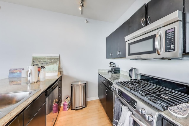 860 W Blackhawk St Unit 805, Chicago, IL 60642 - kitchen with stainless steel appliances, dark cabinets, light wood finished floors, and light stone counters