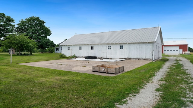 18521 Anderson Rd, Prophetstown, IL 61277 - back of property featuring a yard, an outdoor structure, a metal roof, and an outbuilding