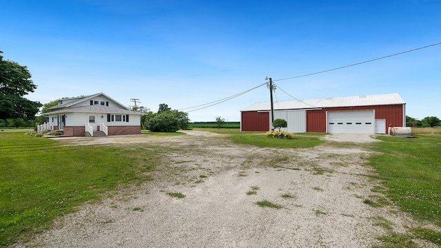 18521 Anderson Rd, Prophetstown, IL 61277 - view of property exterior with a detached garage, dirt driveway, a yard, and an outdoor structure