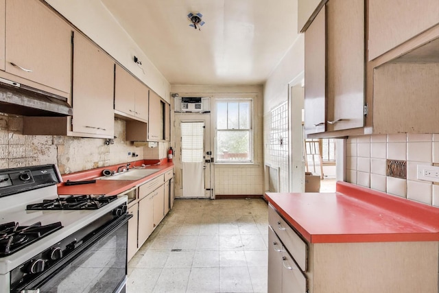 1532 E 59th St Unit J3, Chicago, IL 60637 - kitchen with gas stove, ventilation hood, backsplash, light countertops, and light floors