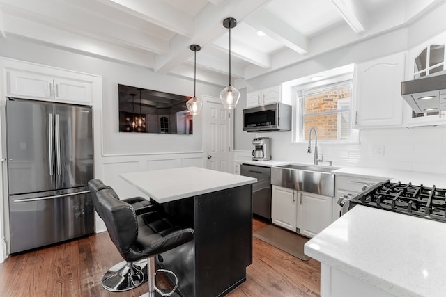 2610 N Major Ave, Chicago, IL 60639 - kitchen with appliances with stainless steel finishes, beamed ceiling, a kitchen breakfast bar, white cabinets, and a center island
