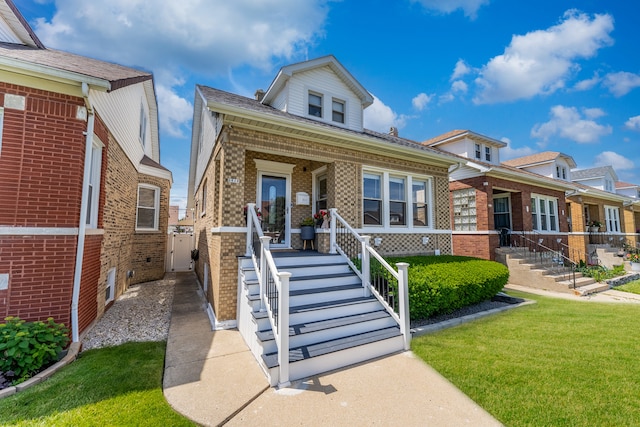 2610 N Major Ave, Chicago, IL 60639 - bungalow with brick siding, covered porch, and a front yard