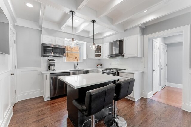 2610 N Major Ave, Chicago, IL 60639 - kitchen with stainless steel appliances, wall chimney range hood, white cabinets, tasteful backsplash, and a center island