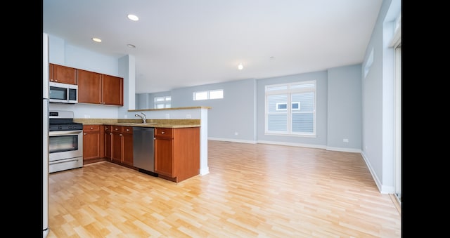 1420 Broadway St Unit 1420, Blue Island, IL 60406 - kitchen with appliances with stainless steel finishes, a peninsula, open floor plan, light wood-style floors, and brown cabinets