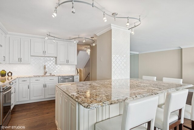 1500 Sheridan Rd Unit 7G, Wilmette, IL 60091 - kitchen featuring appliances with stainless steel finishes, dark wood finished floors, a breakfast bar area, light stone counters, and decorative backsplash