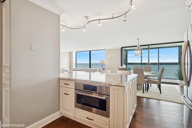 1500 Sheridan Rd Unit 7G, Wilmette, IL 60091 - kitchen featuring cream cabinets, appliances with stainless steel finishes, plenty of natural light, and dark wood-style flooring