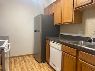 1486 Stonebridge Cir Unit A3, Wheaton, IL 60189 - kitchen with dishwasher, range, light wood finished floors, brown cabinets, and dark countertops