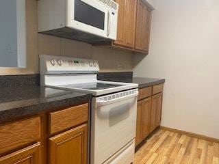 1486 Stonebridge Cir Unit A3, Wheaton, IL 60189 - kitchen with white appliances, brown cabinets, and dark countertops