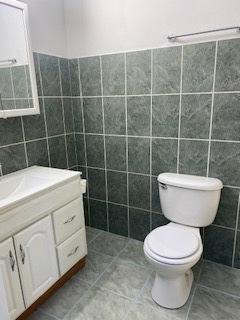 1486 Stonebridge Cir Unit A3, Wheaton, IL 60189 - half bath featuring tile walls, vanity, and tile patterned floors