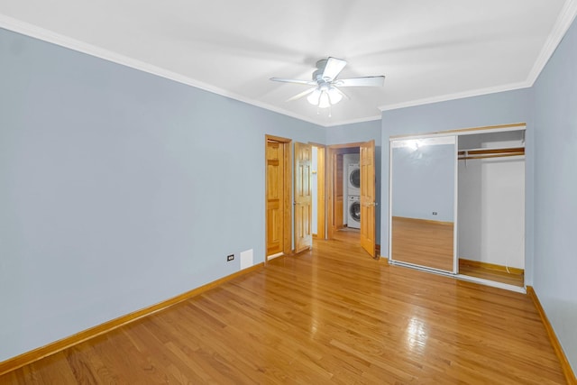10911 S Longwood Dr Unit 2, Chicago, IL 60643 - unfurnished bedroom featuring stacked washing machine and dryer, light wood finished floors, a closet, crown molding, and a ceiling fan
