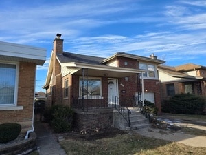 8928 S Bennett Ave, Chicago, IL 60617 - view of front of house with a chimney and brick siding