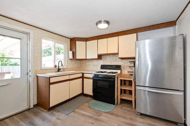 8882 S Main St, Hometown, IL 60456 - kitchen with freestanding refrigerator, gas range, light countertops, light wood-style flooring, and decorative backsplash
