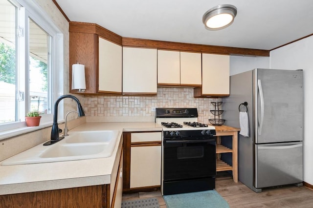 8882 S Main St, Hometown, IL 60456 - kitchen featuring range with gas cooktop, freestanding refrigerator, decorative backsplash, light countertops, and light wood finished floors