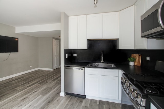 446 Northampton Ln, Roselle, IL 60172 - kitchen featuring appliances with stainless steel finishes, dark countertops, light wood-style flooring, and white cabinetry