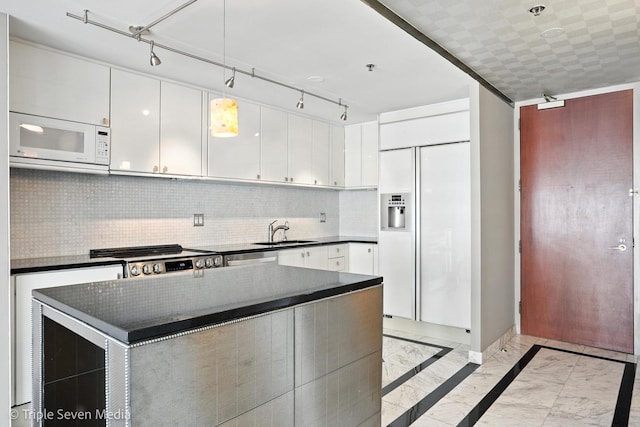 100 E Huron St Unit 2301, Chicago, IL 60611 - kitchen with white microwave, dark countertops, paneled built in fridge, light marble finish floors, and range