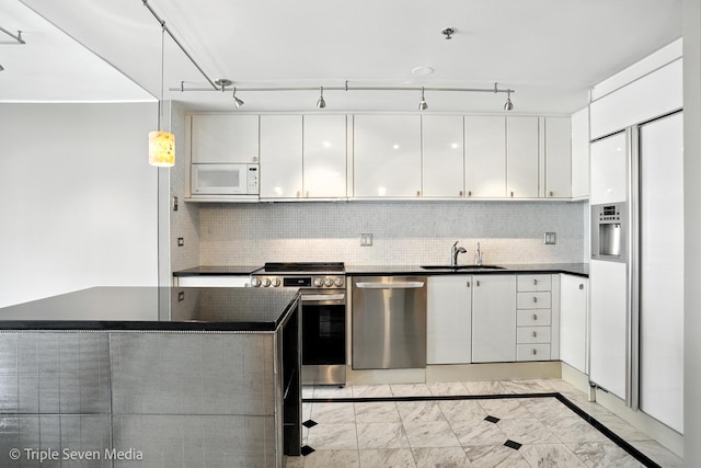 100 E Huron St Unit 2301, Chicago, IL 60611 - kitchen featuring appliances with stainless steel finishes, dark countertops, white cabinets, tasteful backsplash, and pendant lighting