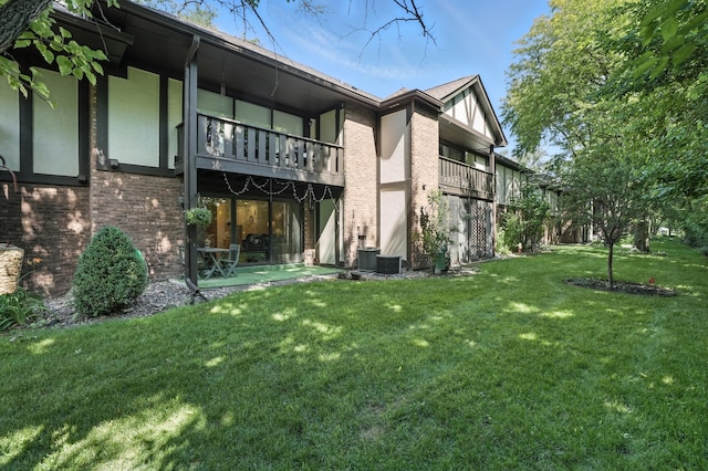 11315 Sycamore Ln Unit B, Palos Hills, IL 60465 - rear view of property with a balcony, a yard, and brick siding
