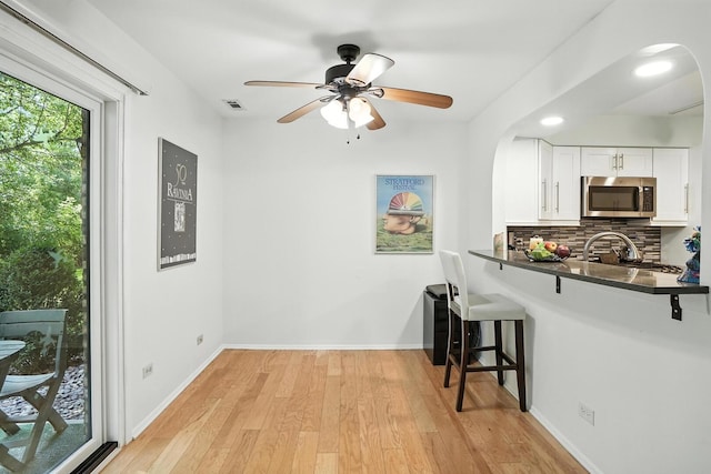 11315 Sycamore Ln Unit B, Palos Hills, IL 60465 - kitchen with stainless steel microwave, arched walkways, dark countertops, and a breakfast bar